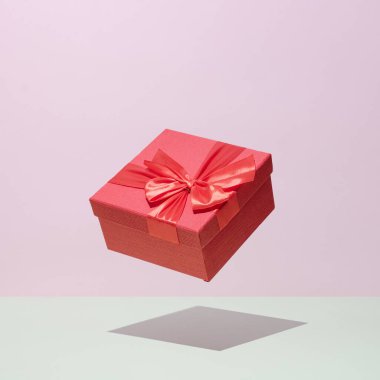 Gift in a red box in levitation on a pastel background wedding celebration congratulations concept.