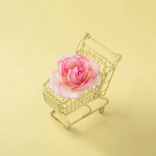 Uma Rosa Carrinho Loja Fundo Amarelo Pastel Conceito Criativo Mínimo — Fotografia de Stock