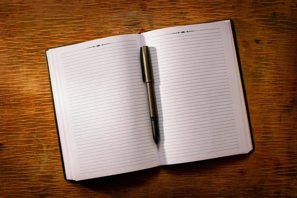 Open notebook on the table and ballpoint pen — Stock Photo, Image