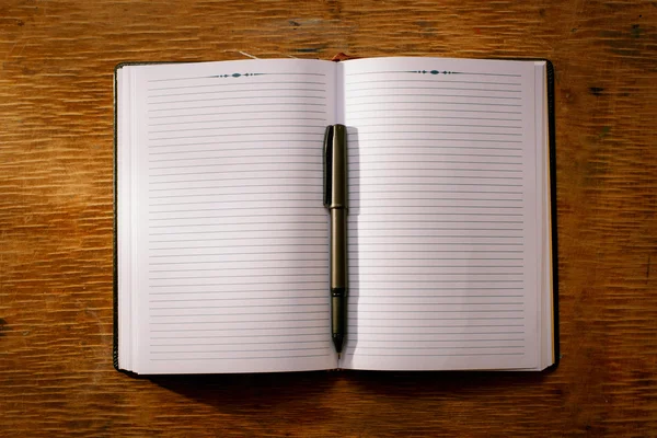 Open notebook on the table and ballpoint pen — Stock Photo, Image