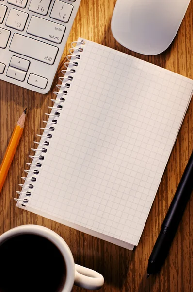 Offenes Notizbuch mit Kaffee neben einer Tastatur — Stockfoto
