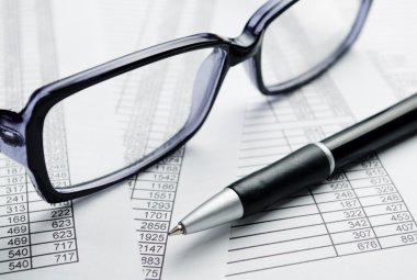 Gözlük ve rapor kağıtları üzerine kalem