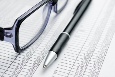 Gözlük ve rapor kağıtları üzerine kalem