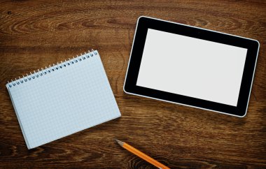 Boş tablet ve ahşap bir masa üstünde defter