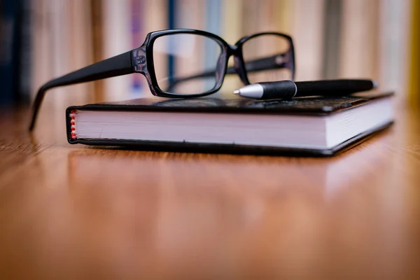 Eyeglasses on Top of the Book at the Table — Stock Photo, Image