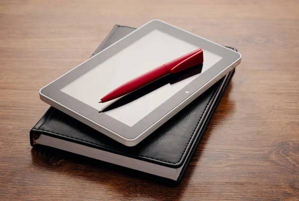 Dispositivo de Tablet no Notebook na mesa de madeira — Fotografia de Stock