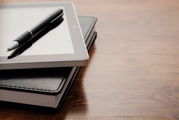 Tablet apparaat op Notebook aan houten tafel — Stockfoto