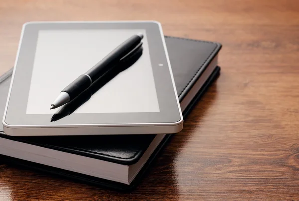 Dispositivo tablet su notebook al tavolo di legno — Foto Stock