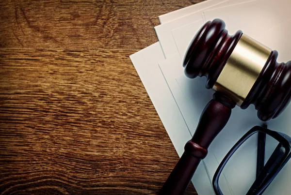 Wooden gavel and glasses on notepaper — Stock Photo, Image