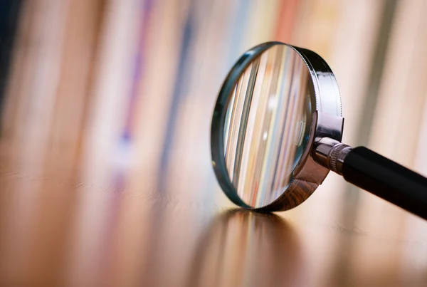 Close up Magnifying Glass Inclinado na mesa de madeira — Fotografia de Stock