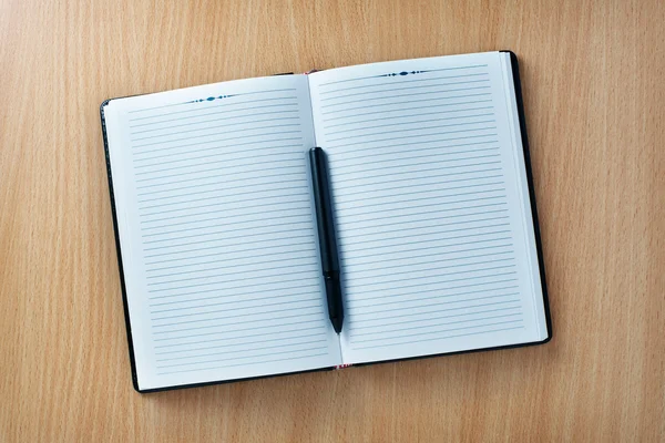 Pen on an open agenda or notebook with blank pages — Stock Photo, Image
