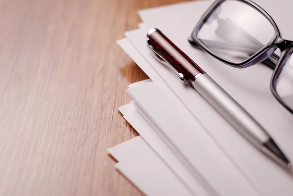 Papel conceitual, caneta e óculos na parte superior da mesa — Fotografia de Stock