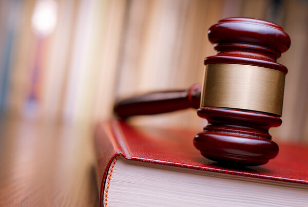 Судьи молотком покоятся на книге законов
