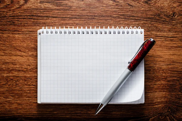 Öppna anteckningsbok och penna på träbord — Stockfoto
