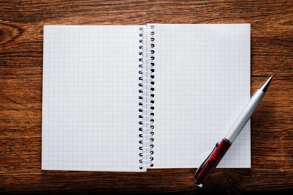 Öppna anteckningsbok och penna på träbord — Stockfoto