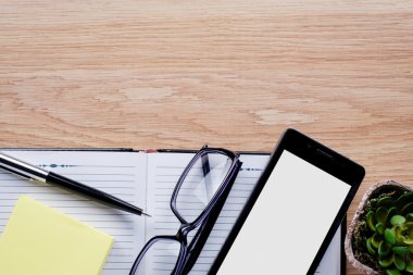 Saksıyı, gözlük, tükenmez kalem ve defter üstünde okul sırası