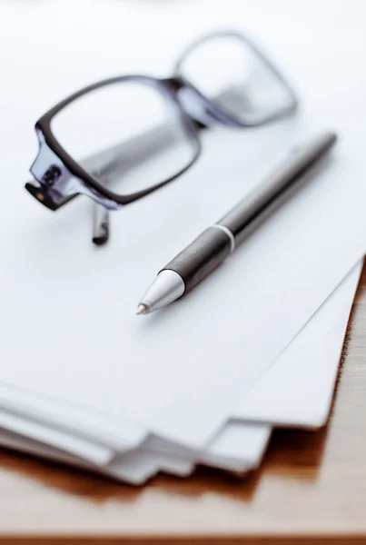 Gafas y bolígrafo sobre papel blanco para notas — Foto de Stock