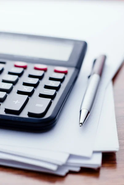 Calculadora, pluma, papel blanco para notas sobre la mesa — Foto de Stock