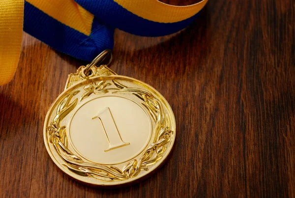 Médaille d'or sur table en bois — Photo