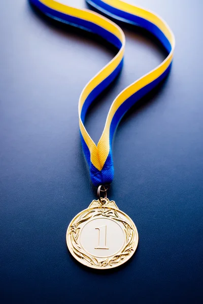 Medalha de ouro sobre fundo azul escuro — Fotografia de Stock