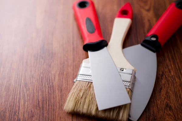 Two paint brush and spatula between them — Stock Photo, Image