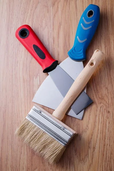 Two spatula and paint brush between them — Stock Photo, Image