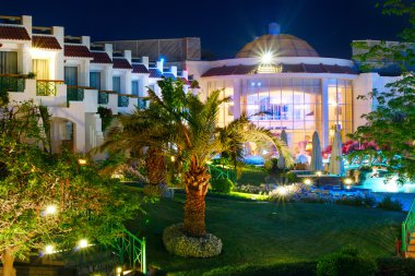 Otel bir yüzme havuzu ve palmiye ağaçları, Mısır. Gece görünümü.