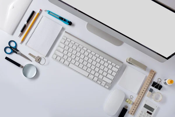 Ο πίνακας λευκό γραφείο με γραφική ύλη αξεσουάρ, πληκτρολόγιο, ποντίκι του υπολογιστή. — Φωτογραφία Αρχείου