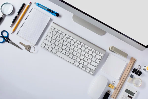 La table de bureau blanche avec accessoires de papeterie, clavier, souris d'ordinateur . — Photo