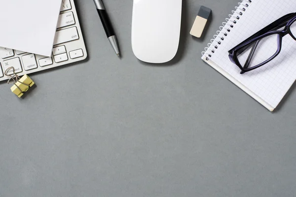 Клавиатура, мышь и офисные принадлежности на сером столе — стоковое фото