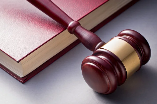 Wooden Gavel Resting on Red Leather Book — Stock Photo, Image