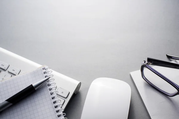 Tastatur, Maus und Bürobedarf auf grauem Schreibtisch Stockbild