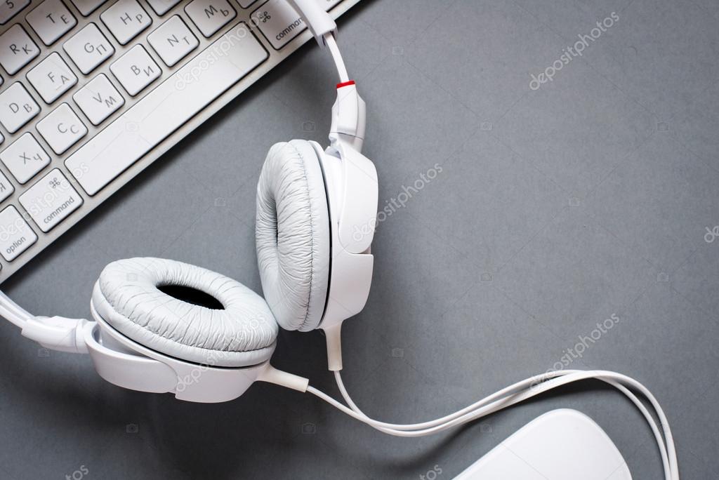 White Headphones and Keyboard on Grey Desk
