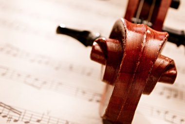 Carved Wooden Violin Scroll Resting on Sheet Music