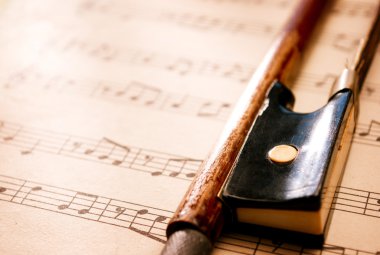 Violin Bow Resting on Sheet Music Composition