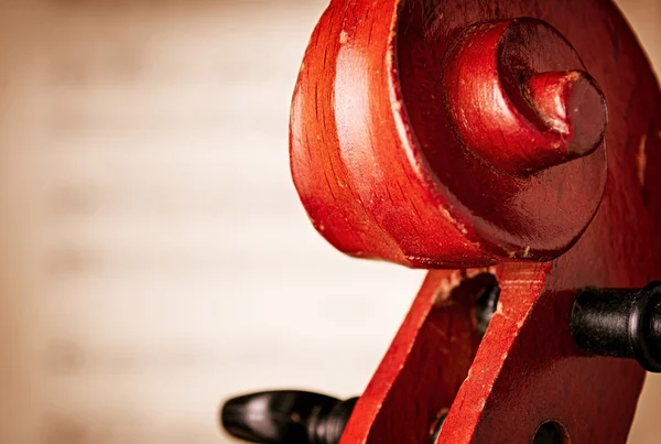 Закрыть скрипичный свиток перед нотным листом — стоковое фото