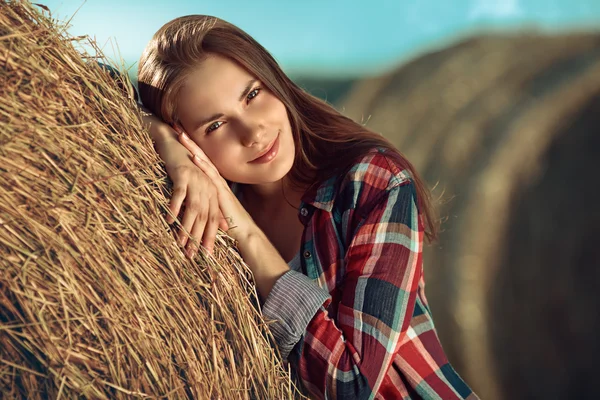 Girl rests against haystack — Stock Photo, Image