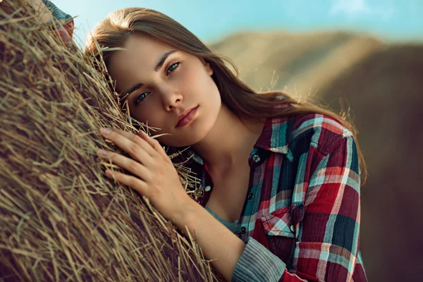 Girl rests against haystack — Stock Photo, Image