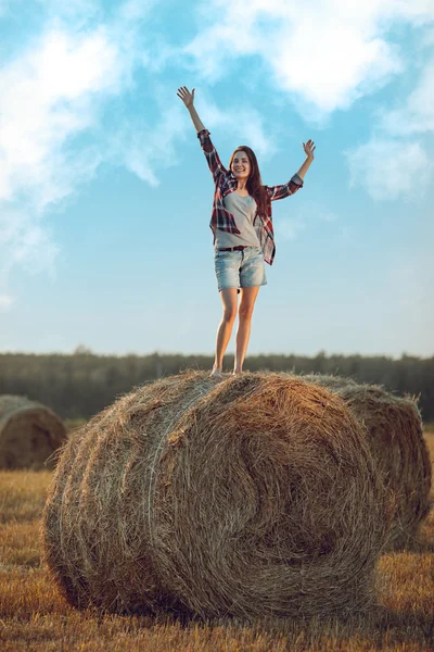 Happy woman standing on haystack — Stock Photo, Image