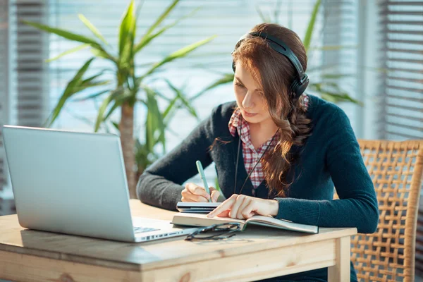 Menina com fones de ouvido e laptop — Fotografia de Stock