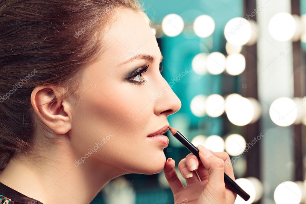Make-upartist applying lip liner