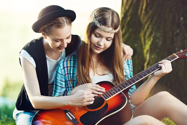 Girls playing guitar in the park — Stock Photo, Image