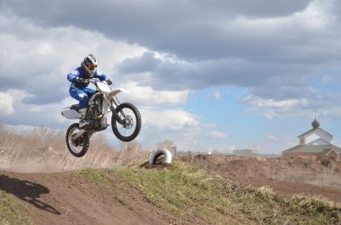 Mx motosiklet üzerinde duran motocross sürücü üzerinde uçuyor