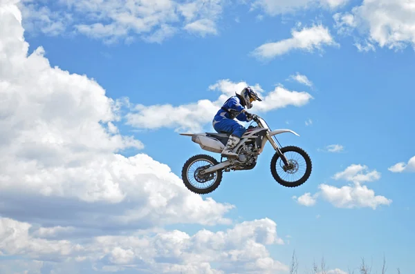 X jogos motorista de pé na motocicleta MX está voando sobre o — Fotografia de Stock