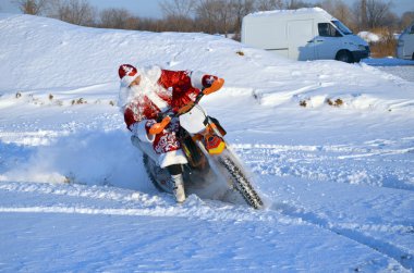 Santa Claus riding on a motorcycle turning MX clipart