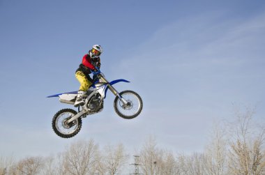 Yüksek hava bulutlu bir arka plan üzerinde bir motosiklet, Mx yarışçı