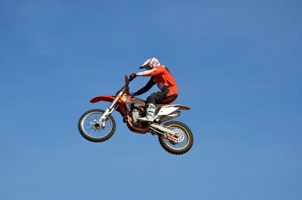 Vrije stijl op een motorfiets vlucht van sportman op de achtergrond van de heldere blauwe hemel — Stockfoto