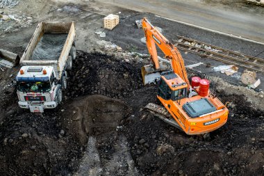 Sibiu, Romanya - 16 Kasım 2019 Kazıcı toprağı çöp kamyonuna yükledi