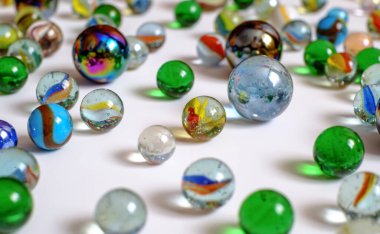 Beyaz arkaplanda çeşitli renk ve boyutlarda cam toplar