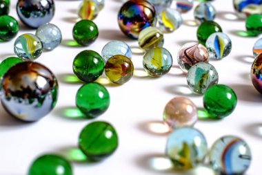 Beyaz arkaplanda çeşitli renk ve boyutlarda cam toplar